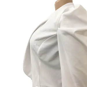 Close-up detail of women's elegant white blazer with pleated puff sleeve design and lapel