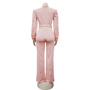 Back view of a pink long sleeve jumpsuit with lace sleeve detail and belt