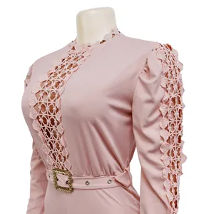 Detail view of pink long sleeve jumpsuit with lace hollow-out and gold buckle belt