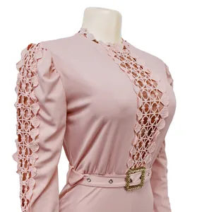 Close-up detail of a pink long sleeve fashion jumpsuit with hollow-out lace and gold buckle belt