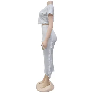 Seitenansicht des weißen zweiteiligen Sets mit Fransen-Crop-Top und langem Maxirock