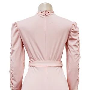 Back detail of pink long sleeve jumpsuit featuring lace hollow-out trim and belt.