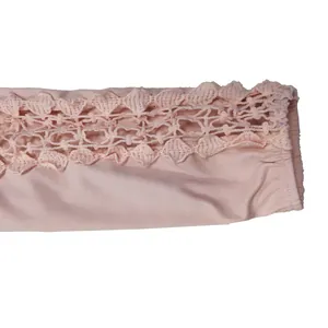 Close-up view showing the delicate lace hollow-out detail on the light pink sleeve cuff.