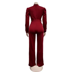 Detail view of burgundy long sleeve jumpsuit with elegant lace and matching belt
