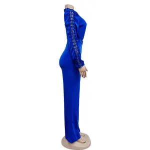 Side profile of a vibrant blue long-sleeve jumpsuit with intricate lace sleeve details.