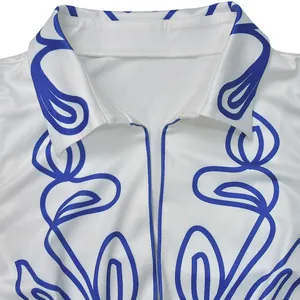 Close-up view of elegant white shirt with abstract blue line patterns and neat stitching.