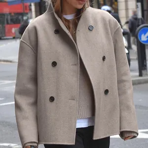 Detail of a chic taupe double-breasted wool coat in a classic British street style.