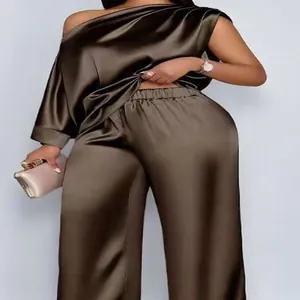 Elegant satijnen tweedelig setje in brons met off-shoulder top en wijde broek