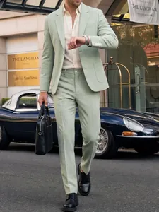 Mannequin portant un costume d'affaires vert sauge cintré dans un cadre extérieur