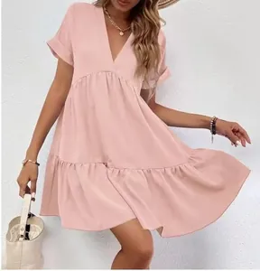 Détail d'une robe courte rose poudré à col en V avec ourlet à volants et manches