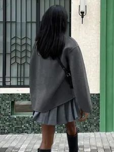 Back view of a chic grey wool coat paired with a matching pleated skirt