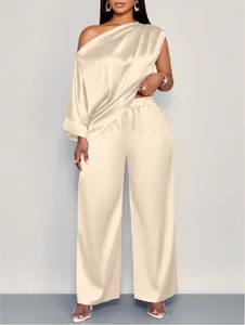 Elegant champagne satijnen set voor dames met one-shoulder top en broek met wijde pijpen.