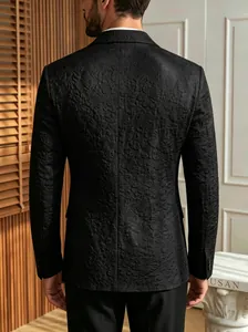 Gedetailleerd achteraanzicht van een zwart jacquard herenpak met gebosseleerd bloemenpatroon