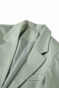 Nahaufnahme des Revers einer salbeigrünen Herrenanzugjacke mit hochwertiger Textur