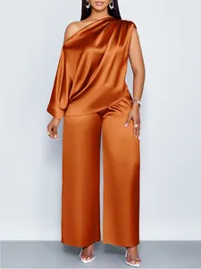 Elegante oranje satijnen set bestaande uit een one-shoulder top en wijde broek