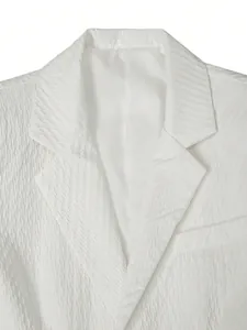 Vue macro d'un blazer à manches courtes texturé blanc avec un col tailleur classique