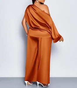 Achteraanzicht van elegante roestoranje satijnen set met one-shoulder top en wijde broek