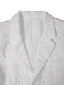 Gedetailleerde weergave van elegante witte jacquardstof op de revers van een herenblazer.