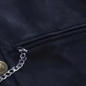 Detail shot of a navy suede business vest featuring a silver chain and bronze button