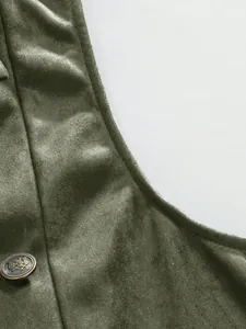 Close-up of olive green velvet men's vest featuring a vintage metallic crest button