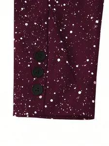 Close-up of burgundy suit sleeve featuring white splatter print and three black buttons