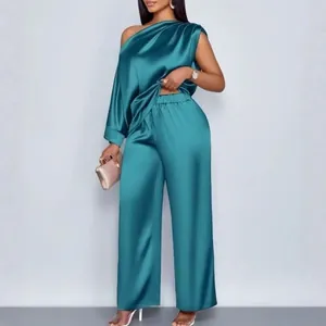 Elegante groenblauwe satijnen set met one-shoulder top en wijde broek met rechte pijpen