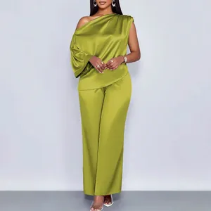 Chique limoengroene satijnen tweedelige outfit met one-shoulder top en lange broek