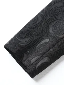 Makroansicht von schwarzem Rosen-Jacquard-Stoff an einer Anzugmanschette
