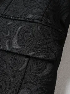 Makro-Detail von schwarzem Paisley-Jacquard-Stoff eines eleganten Herren-Abendanzugs.