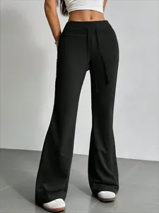 Detalle de pantalones de campana negros de cintura alta con cordón ajustable.