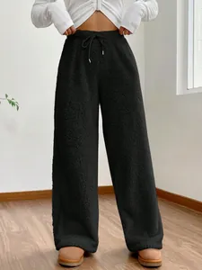Detail view of black plush high-waist sweatpants with drawstring waist and loose fit
