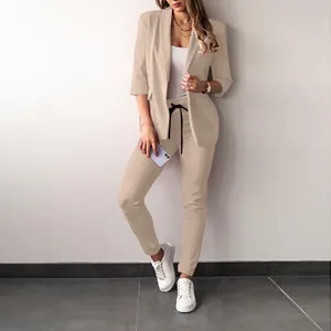 Full body view of a stylish beige casual blazer and matching trousers suit set for women