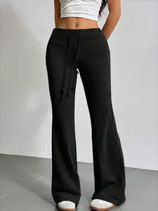 Detalle de los pantalones negros de talle alto acampanados con cordón ajustable de moda