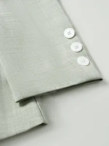 Gros plan sur le tissu texturé vert clair et les boutons blancs d'un costume pour homme