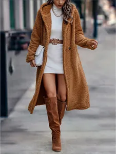 Detailansicht eines braunen Teddy-Kapuzenmantels mit weißem Kleid und Stiefeln im Straßenstil.