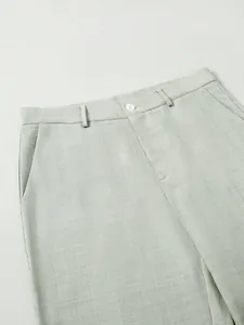 Détail de la taille d'un pantalon de costume vert clair pour homme avec passants et bouton
