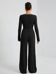 Vista posterior de un conjunto de dos piezas de punto acanalado negro con pantalón ancho
