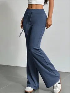 Detalle de vista lateral de pantalones acampanados azules con cordón y textura suave.