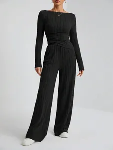 Imagen de cuerpo entero de un conjunto de punto negro con top de manga larga y pantalón