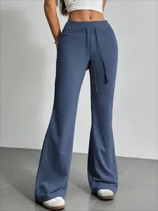 Detalle de pantalones campana azules de cintura alta para mujer con cordón ajustable