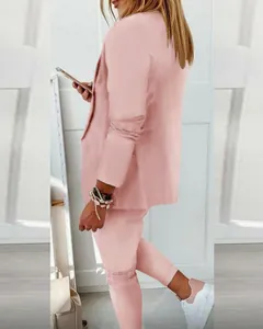 Side view of elegant light pink women's casual blazer and matching trousers set