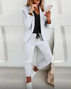 Full body view of white women's casual blazer set with drawstring trousers and sneakers