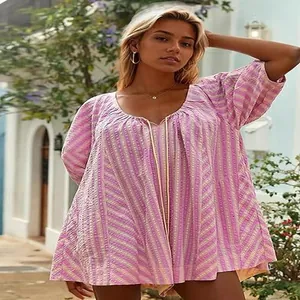 Detailed view of model wearing a pink and yellow striped loose deep V-neck summer romper