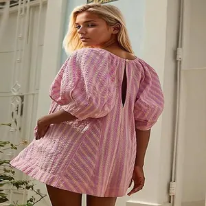 Close-up back view of a pink and yellow striped mini dress with a teardrop cutout detail