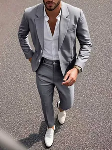 Détail de la texture du tissu et de la coupe ajustée d'un blazer gris pour homme.