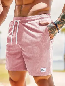 Nahaufnahme einer rosa Cord-Shorts für Herren mit weißem Kordelzug und Aufnäher-Detail.