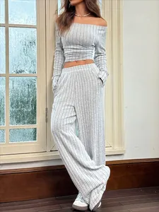 Modelo con conjunto de punto de canalé a rayas grises con top sin hombros y pantalón ancho