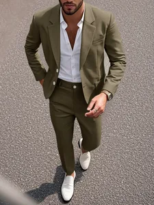 Détail d'un costume pour homme vert olive avec chemise blanche et mocassins blancs.