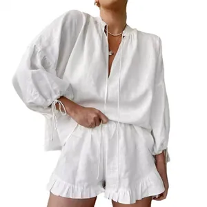 White linen two-piece set featuring a lantern sleeve top and ruffled high-waist shorts