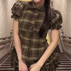 Close-up of retro brown plaid shirt with ruffled puff sleeves and button front